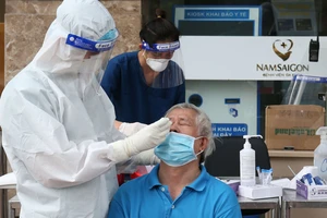 Nhân viên y tế Bệnh viện Đa khoa Quốc tế Nam Sài Gòn lấy mẫu xét nghiệm cho người dân. Ảnh: HOÀNG HÙNG