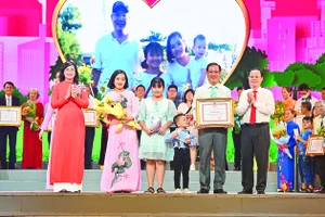Phó Bí thư Thành ủy TPHCM Nguyễn Văn Hiếu và Phó Chủ tịch UBND TPHCM Phan Thị Thắng chúc mừng các gia đình được tuyên dương. Ảnh: PHƯƠNG NGHI