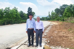 Ông Lê Triều (bên phải) bên diện tích đất mà gia đình ông hiến để làm đường Âu Cơ