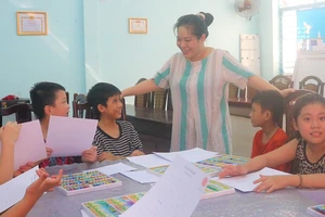 Cô Phạm Thị Nhật Nghi dạy vẽ miễn phí cho các em. Ảnh: XUÂN QUỲNH