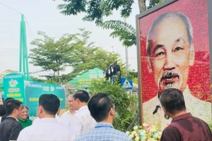 Người dân và du khách ngắm nhìn bức tranh kính chân dung Chủ tịch Hồ Chí Minh được ghép từ 1.944 tấm ảnh hoa sen