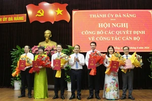 Ông Nguyễn Đình Vĩnh, Phó Bí thư Thường trực Thành ủy Đà Nẵng trao quyết định, tặng hoa chúc mừng các đồng chí được phân công, điều động và bổ nhiệm