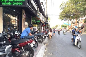 Mặc dù vỉa hè đường Nguyễn Thị Minh Khai (phường Đa Kao, quận 1) chỉ rộng hơn 1m nhưng các quán cà phê vẫn chiếm hết diện tích làm chỗ đậu xe máy, đẩy người đi bộ xuống lòng đường
