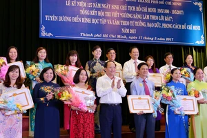 Phó Bí thư Thường trực Thành ủy TPHCM Tất Thành Cang cùng các đồng chí lãnh đạo TPHCM tuyên dương các tác giả đoạt giải tại hội thi “Gương sáng làm theo lời Bác” Ảnh: VIỆT DŨNG