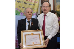 Bí thư Thành ủy TPHCM Nguyễn Thiện Nhân trao huy hiệu 70 năm tuổi đảng cho đồng chí Nguyễn Ngọc Cẩm. Ảnh:Việt Dũng