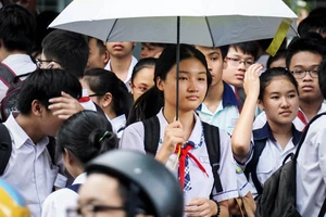 Thí sinh kết thúc thi môn Anh văn tại điểm thi Trường THCS ra về trong cơn mưa tầm tã