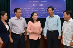 Trưởng ban Dân vận Thành ủy TPHCM Nguyễn Thị Lệ trao đổi cùng các đại biểu tại hội nghị . Ảnh: VIỆT DŨNG