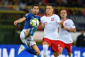 Tiền vệ Jorginho (trái, Italia) tranh bóng với Ba Lan