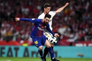 Lio Messi đi bóng qua hậu vệ Sevilla