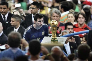 Leo Messi không thể không nhìn vào chiếc Cúp thể giới khi đi ngang qua nó ở Maracana.