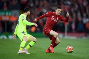 Andy Robertson (phải) cố gắng đi bóng qua Lionel Messi