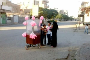 Trẻ em Syria mua kẹo bông gòn trên đường phố Raqqa. Ảnh: Anadolu Agency