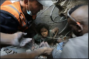 Người Palestine cứu một cô gái ra khỏi đống đổ nát của tòa bị phá hủy bởi cuộc không kích của Israel ở trại tị nạn Jabaliya, phía bắc Dải Gaza. Ảnh: AP 