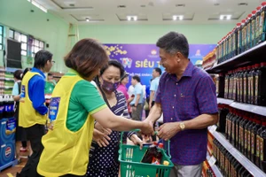 Đại diện Ban tổng giám đốc Saigon Co.op hỗ trợ người dân mua hàng tại hệ thống siêu thị mini 0 đồng