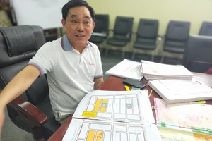 Ông Huỳnh Uy Dũng bên sơ đồ vị trí 255 lô đất nền muốn tặng