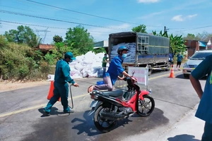 Lực lượng chức năng xã An Bình, huyện Phú Giáo phun thuốc khử khuẩn phương tiện ở ấp Cà Na. Ảnh chụp tháng 2-2021