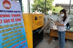 Người dân nhận gạo hỗ trợ từ chương trình ATM gạo ở phường Vĩnh Phú, TP Thuận An