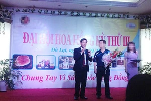 Nguyễn Thế Anh (trái) trong một buổi đại hội chi trả hoa hồng cho nhà đầu tư