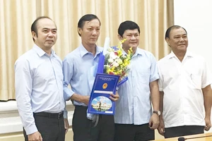 Phó Chủ tich UBND TPHCM Huỳnh Cách Mạng (thứ hai từ phải sang) và ông Hồ Văn Ngon (thứ ba từ phải sang) tại buổi trao quyết định. Ảnh: KIỀU PHONG
