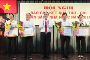 Bí thư Thành ủy TPHCM Nguyễn Thiện Nhân trao tặng bằng khen của UBND TPHCM đối với các địa phương hoàn thành xuất sắc công tác thu nộp ngân sách Nhà nước trên địa bàn thành phố năm 2018. Ảnh: KIỀU PHONG