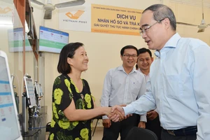 Bí thư Thành uỷ TPHCM Nguyễn Thiện Nhân thăm hỏi người dân về dịch vụ hành chính công tại UBND quận Bình Thạnh. 