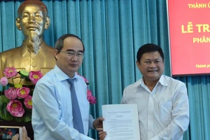 Bí thư Thành ủy TPHCM Nguyễn Thiện Nhân trao quyết định cho đồng chí Huỳnh Cách Mạng. Ảnh: VIỆT DŨNG