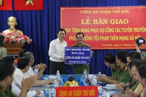 Đại tá Lê Anh Tuấn, Trưởng Công an quận Thủ Đức nhận máy tính bảng từ nhà tài trợ 