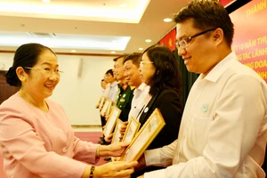 Phó Bí thư Thành ủy Võ Thị Dung tặng bằng khen cho các cá nhân tại hội nghị tổng kết 10 năm thực hiện Chỉ thị 22-CT/TW của Ban Bí thư. Ảnh: VIỆT DŨNG 