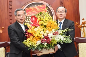 Đồng chí Nguyễn Thiện Nhân tặng hoa chúc mừng Đức Tổng Giám mục Nguyễn Năng. Ảnh: VIỆT DŨNG