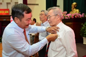 Bí thư Quận ủy quận 2 Trần Văn Thuận (trái) trao Huy hiệu Đảng cho các đảng viên cao tuổi Đảng trên địa bàn quận. Ảnh: KIỀU PHONG 