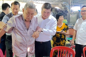 Chủ tịch UBND TPHCM ân cần thăm hỏi sức khỏe ông Huỳnh Quang Hải và gia đình ông. Ảnh: KIỀU PHONG 