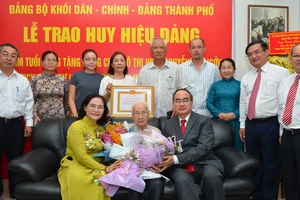 Bí thư Thành ủy TPHCM Nguyễn Thiện Nhân cùng các đồng chí lãnh đạo TP, gia đình chúc mừng đồng chí Ngô Thị Huệ đón nhận huy hiệu 85 năm tuổi đảng. Ảnh: VIỆT DŨNG