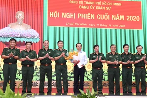 Bí thư Thành ủy TPHCM Nguyễn Văn Nên nhận hoa chúc mừng giữ chức vụ Bí thư Đảng ủy Quân sự TPHCM, sáng 11-12-2020. Ảnh: VIỆT DŨNG