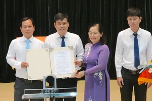 Chủ tịch HĐND TPHCM Nguyễn Thị Lệ trao Nghị quyết 1111 của Ủy ban Thường vụ Quốc hội tới lãnh đạo 3 phường 6, 7 và 8 (quận 3). Ảnh: KIỀU PHONG