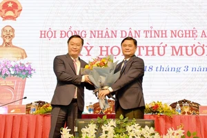 Bí thư tỉnh ủy Nghệ An Thái Thanh Quý (bên phải) tặng hoa tân Chủ tịch UBND tỉnh Nguyễn Đức Trung 