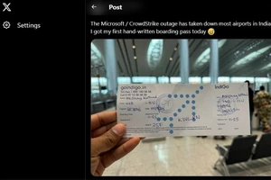 Một hành khách tại Ấn Độ lên máy bay với thẻ viết tay do sự cố của Microsoft. Ảnh: X