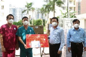 Đồng chí Dương Ngọc Hải trao bảng tượng trưng tặng trang thiết bị y tế cho Bệnh viện dã chiến thu dung điều trị Covid-19 số 12. Ảnh: ĐÌNH LÝ