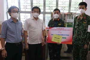 Đồng chí Dương Ngọc Hải tặng quà động viên lực lượng y, bác sĩ làm nhiệm vụ tại một trạm y tế lưu động ở quận Tân Phú. Ảnh: ĐÌNH LÝ