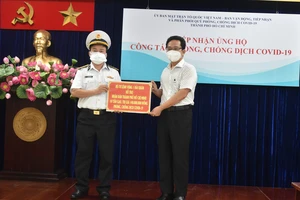Ông Phạm Minh Tuấn tiếp nhận bảng tượng trưng ủng hộ 10 tấn gạo của Bộ Tư lệnh Vùng 1 Hải quân trao tặng