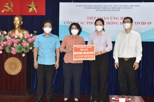 Chủ tịch Ủy ban MTTQ Việt Nam TPHCM Tô Thị Bích Châu tiếp nhận bảng tượng trưng ủng hộ từ Đảng ủy Khối Dân - Chính - Đảng TPHCM. 