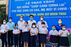 Trao tặng học bổng “chắp cánh tương lai” cho học sinh có cha, mẹ mất vì Covid-19 và các em có hoàn cảnh khó khăn ở phường 6, quận 8. Ảnh: MẠNH HOÀ