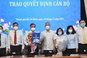 Phó Chủ tịch UBND TPHCM Võ Văn Hoan trao quyết định và tặng hoa chúc mừng ông Lê Văn Cửa