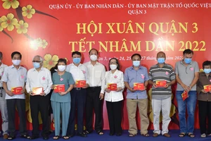 Phó Bí thư Thành ủy TPHCM Nguyễn Hồ Hải trao quà cho các gia đình chính sách. Ảnh: ĐÌNH LÝ