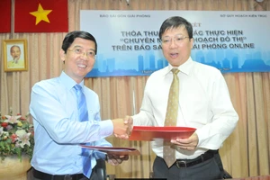 Phó Tổng Biên tập Báo SGGP Nguyễn Thành Lợi và Giám đốc Sở Quy hoạch- Kiến trúc TPHCM Nguyễn Thanh Nhã trao đổi bản ký kết thoả thuận hợp tác