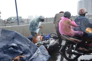 Người dân lưu thông trên cầu té ngã vì đường trơn trượt trong cơn mưa lớn. Ảnh: C.T