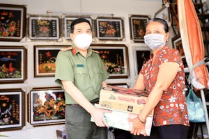 Đại tá Nguyễn Sỹ Quang, Phó Giám đốc Công an TPHCM trao quà cho gia đình chị Thuỷ. Ảnh: DŨNG PHƯƠNG