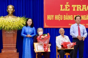 Chủ tịch HĐND TPHCM Nguyễn Thị Lệ trao Huy hiệu 75 năm tuổi Đảng cho đồng chí Lê Văn Nghi và Huy hiệu 60 năm tuổi Đảng cho đồng chí Chu Thị Ngọ. Ảnh: CAO THĂNG