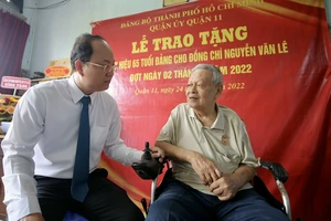 Phó Bí thư Thành ủy TPHCM Nguyễn Hồ Hải ân cần hỏi thăm đồng chí Nguyễn Văn Lê. Ảnh: DŨNG PHƯƠNG