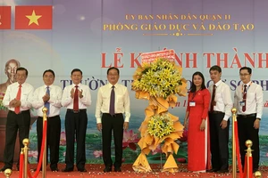 Bí thư Quận ủy quận 11 Trương Quốc Lâm; Quyền Chủ tịch UBND quận 11 Nguyễn Trần Bình tặng hoa chúc mừng nhà trường. Ảnh: CHÍ THẠCH