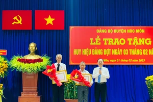 Phó Bí thư Thành ủy TPHCM Nguyễn Văn Hiếu trao Huy hiệu Đảng đợt 3-2 cho các đảng viên cao tuổi Đảng ở huyện Hóc Môn. Ảnh: CHÍ THẠCH